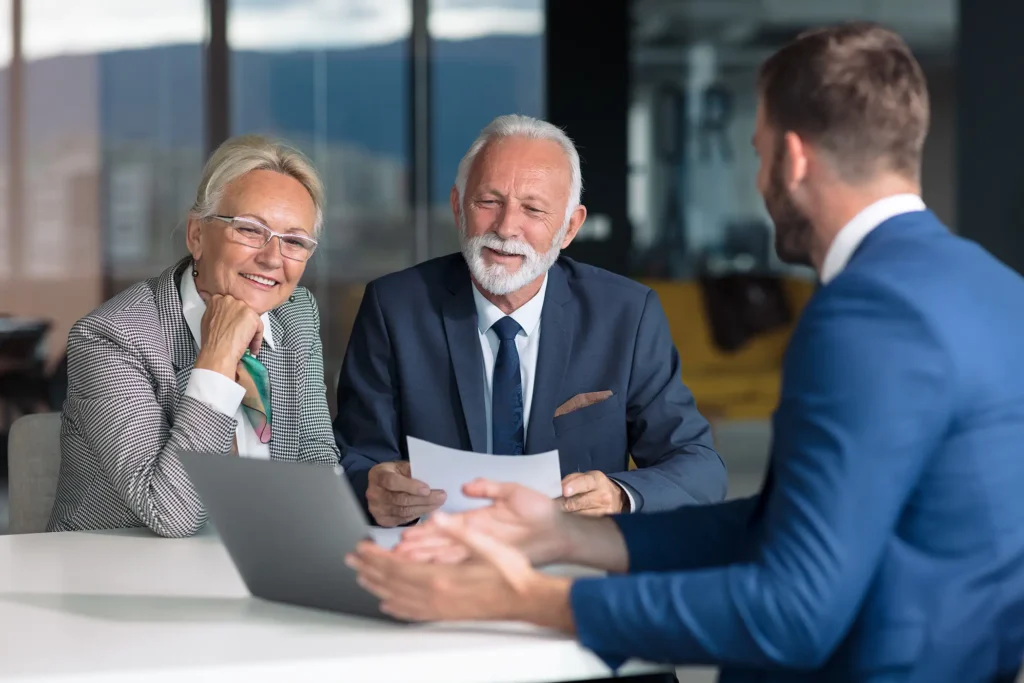 Positive aged couple consulting with insurance agent